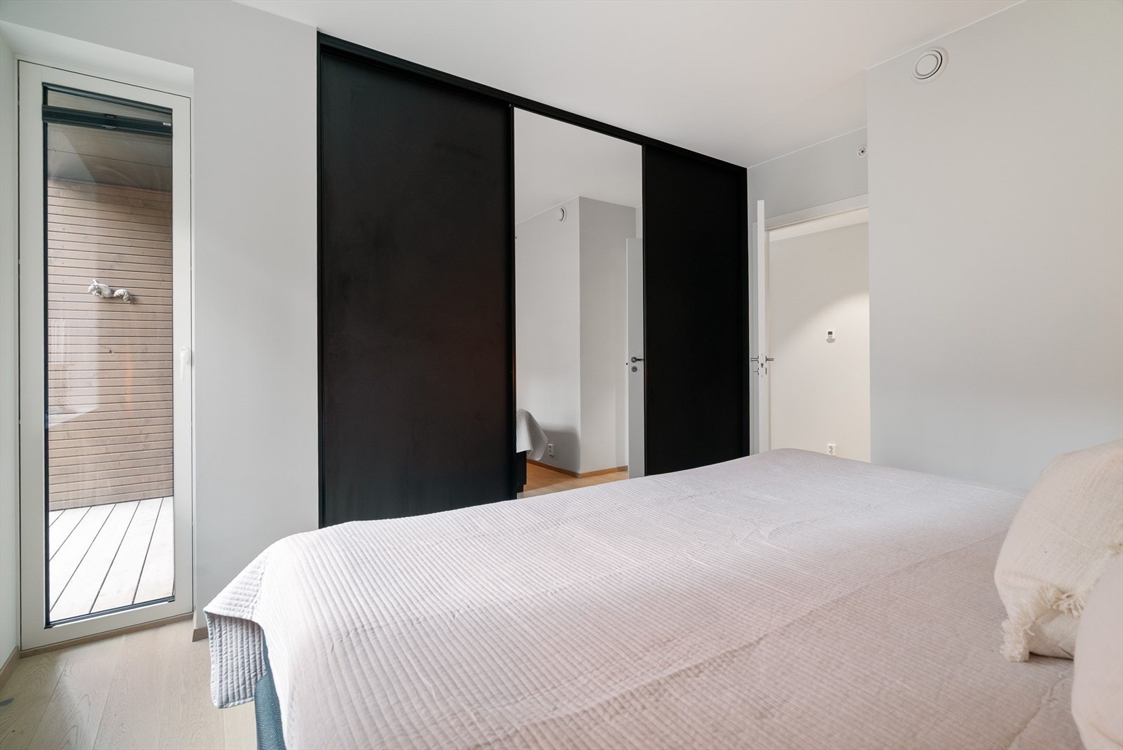 Hovedsoverommet er innredet med en stor og stilren skyvedørsgarderobe, og det er i tillegg adkomst til terrasse via vindu. Galleribilde