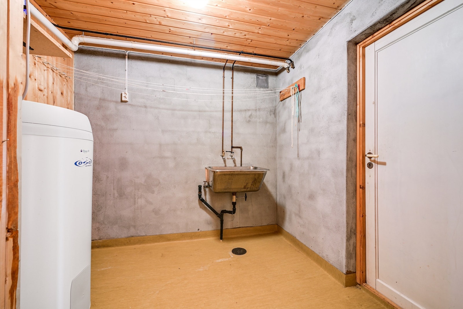 Separat vaskerom med opplegg for vaskemaskin. Her er også boligens varmtvannsbereder fra 2009 plassert. Galleribilde