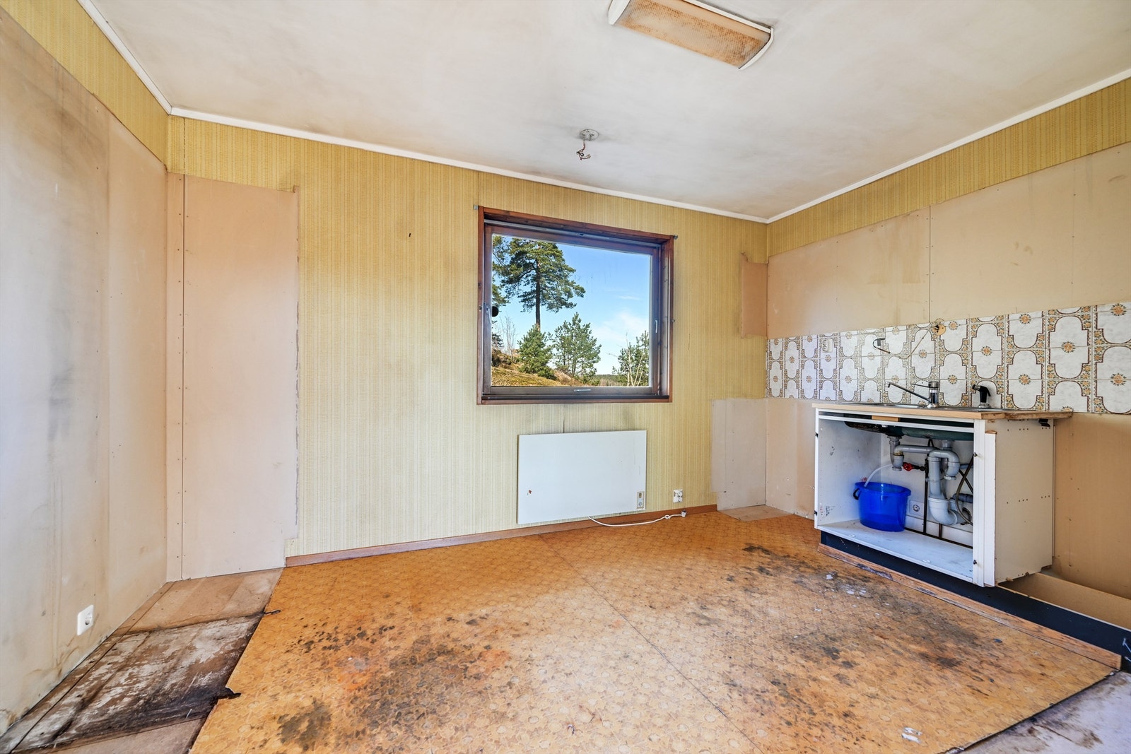 Rommet er et separat kjøkken i hovedetasjen, med utsikt mot naturen bak huset. Galleribilde