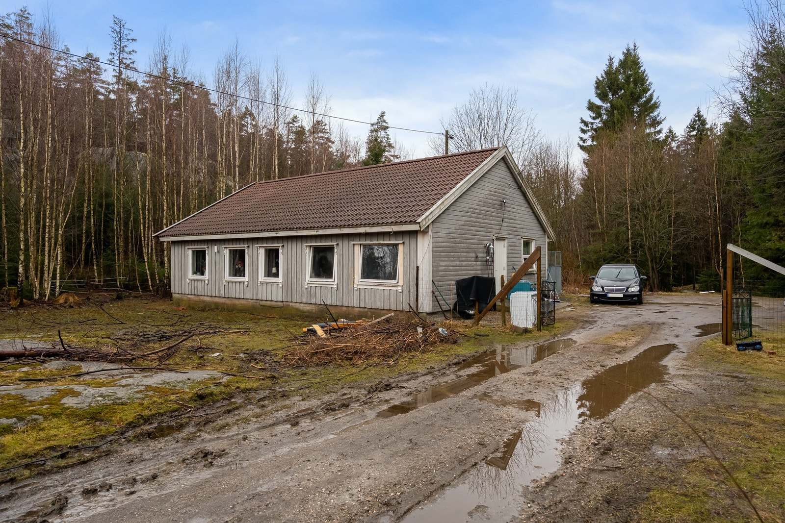 Boligen ligger tilbaketrukket innerst på tomten. Galleribilde