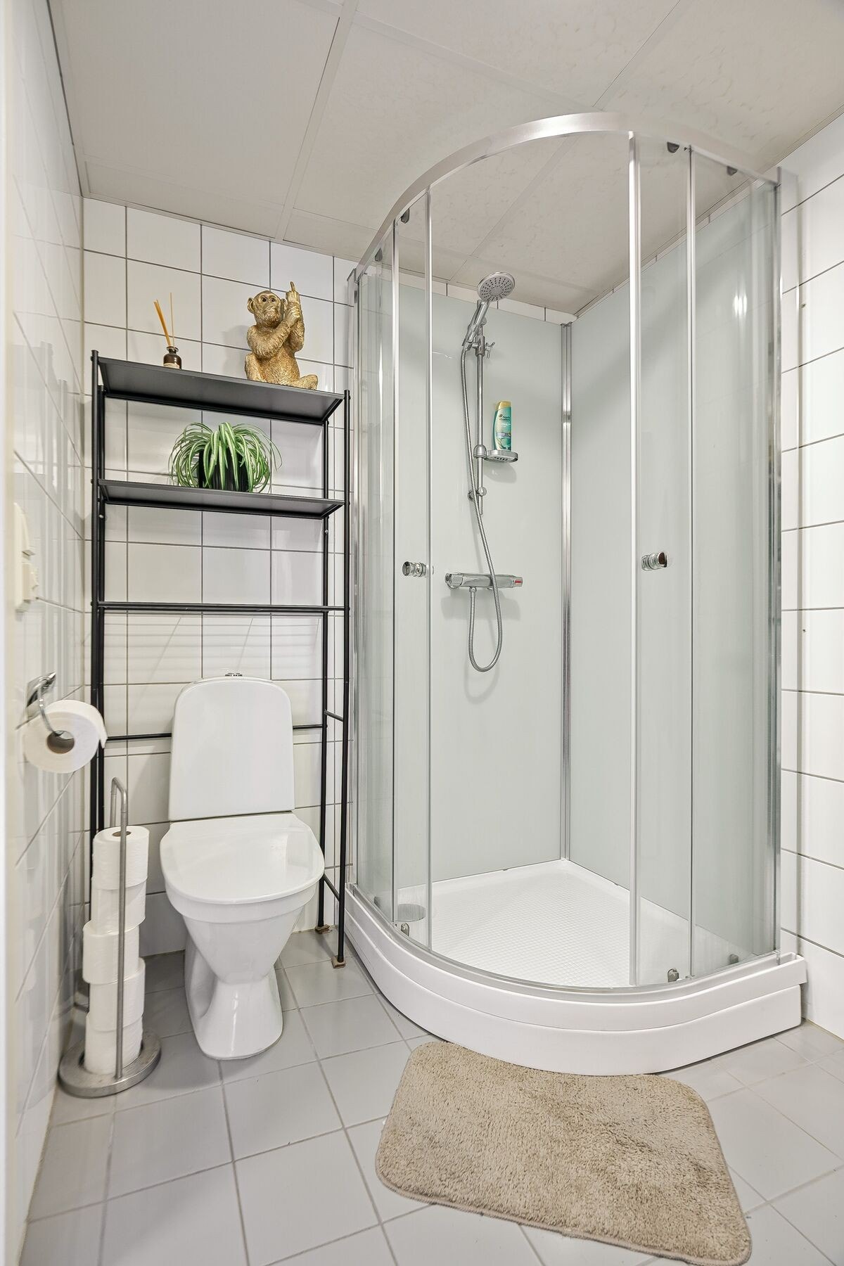 Badet er utstyrt med baderomsinnredning, dusjkabinett, toalett og opplegg for vaskemaskin Galleribilde