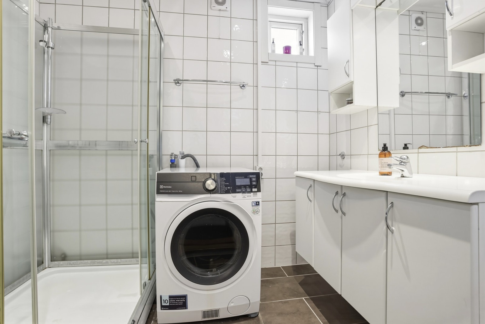 Badet i 1.etg. ble oppført i 2010 og inneholder gulvmontert toalett, innredning med heldekkende vask, opplegg til vaskemaskin og dusjkabinett. Galleribilde