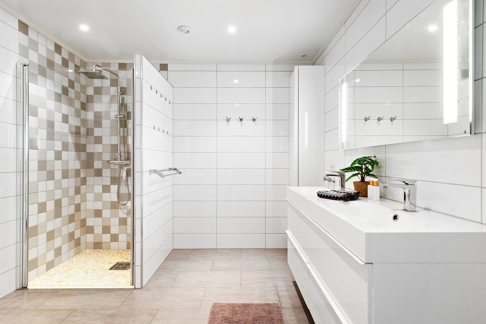 Badet har dobbel servant, speil med integrert belysning, vegghengt toalett og dusj. Galleribilde