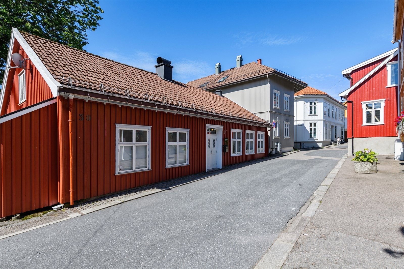 Dette er en sjarmerende halvpart av vertikeldelt tomannsbolig. Leiligheten har privat adkomst via den hvite døren, og ligger til høyre i bygget (3 vinduer). Galleribilde