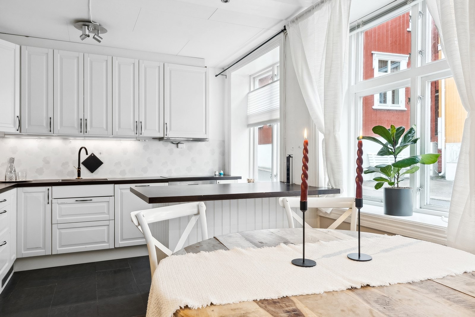 Kjøkken og stue ligger i åpen løsning, med kjøkkenet fint trukket tilbake i eget hjørne. Galleribilde