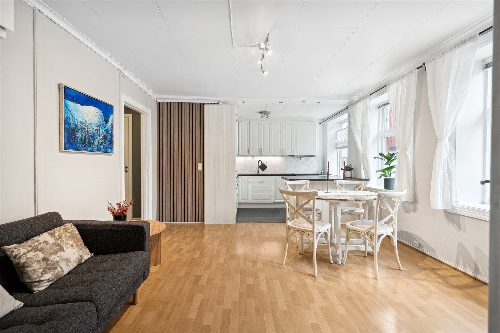 Stuen er lys og koselig. Det er parkett på gulv i fleste værelser, samt lysmalte vegger. Legg også merke til den stilige spileveggen som gir en fin kontrast til rommet. Galleribilde