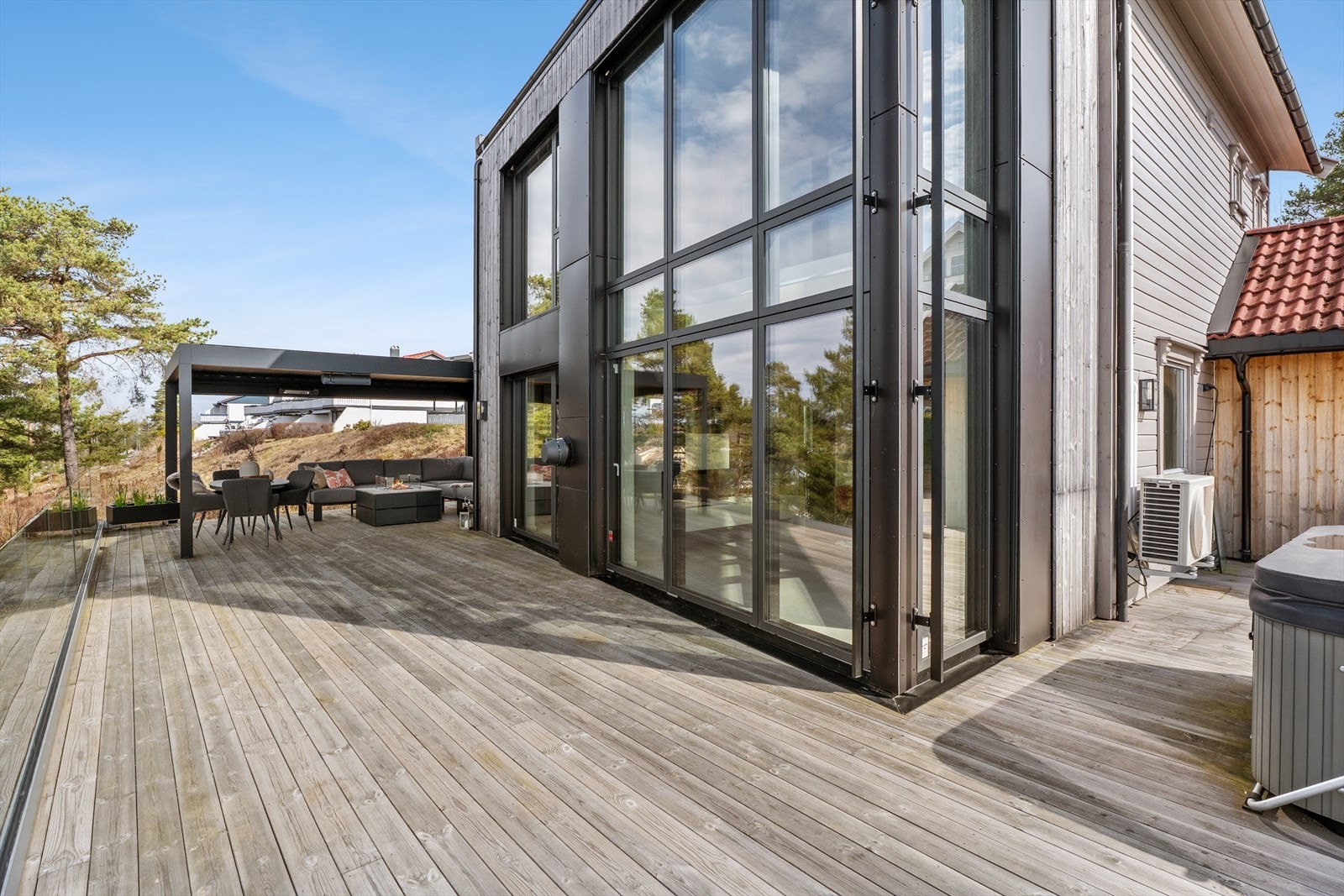 Romslig uteplass med pergola på ca. 23 m² - i tillegg til en flott terrasse på ca. 40 m² med jacuzzi for ekstra komfort Galleribilde