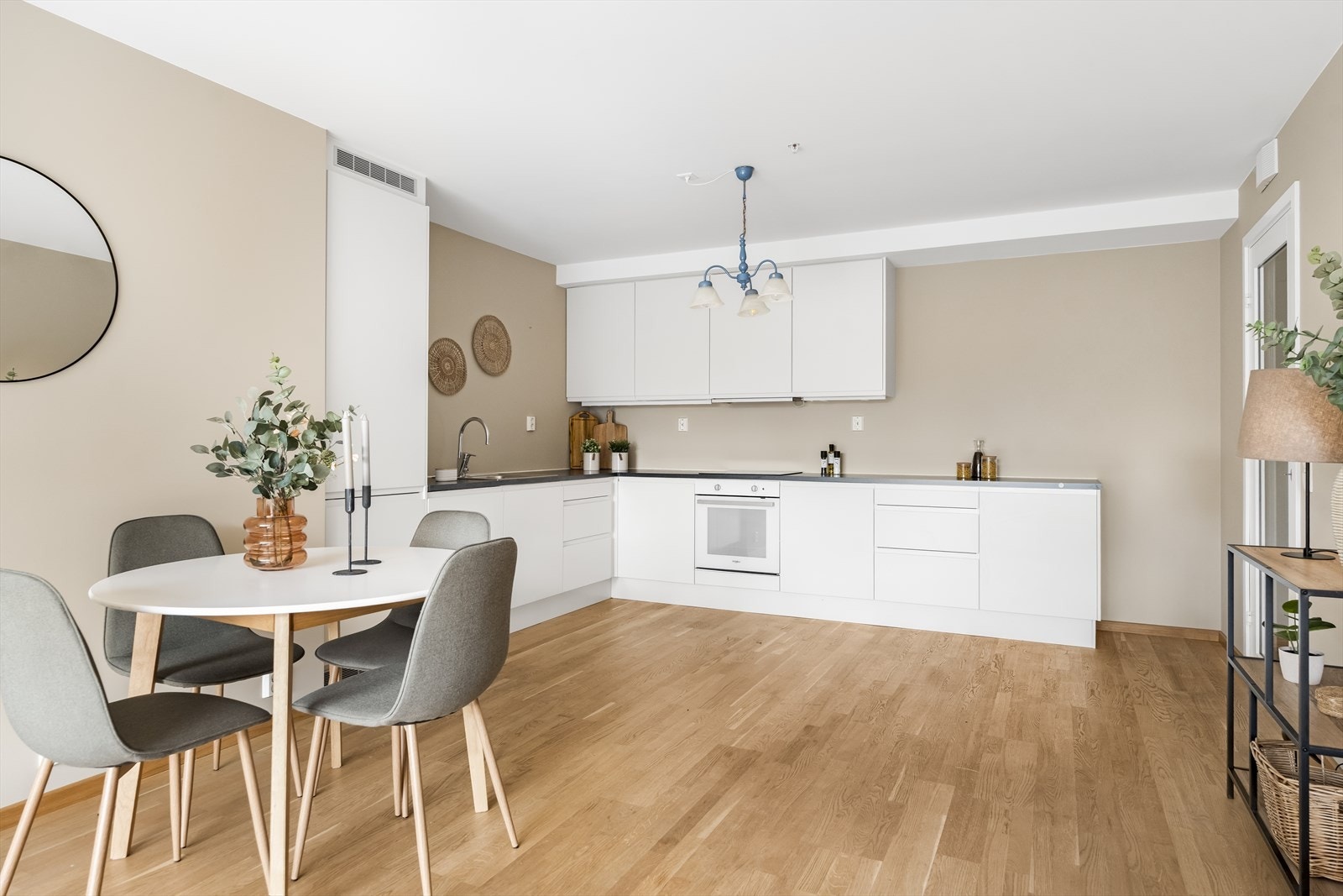 Flott og stilrent kjøkken med hvite, glatte fronter med laminert benkeplate i sort og planlimt kum i rustfritt stål. Galleribilde