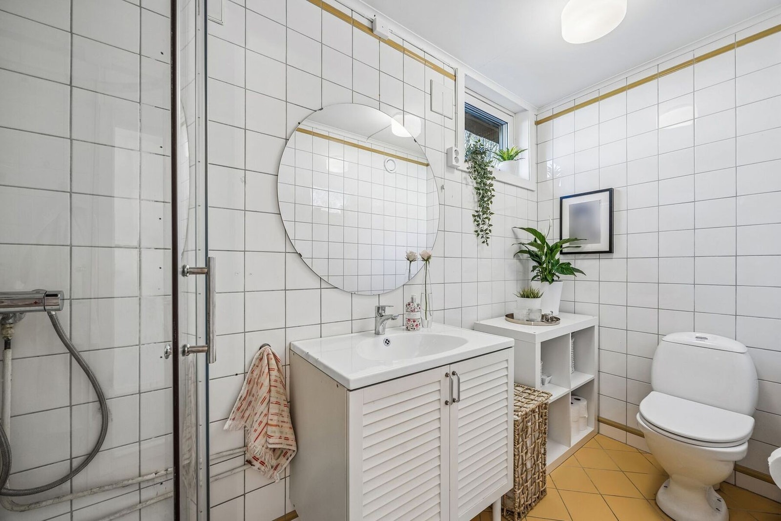 Et funksjonelt bad med flislagte overflater, servant og dusjløsning. Rommet er praktisk innredet og dekker alle daglige behov på en effektiv måte. Galleribilde