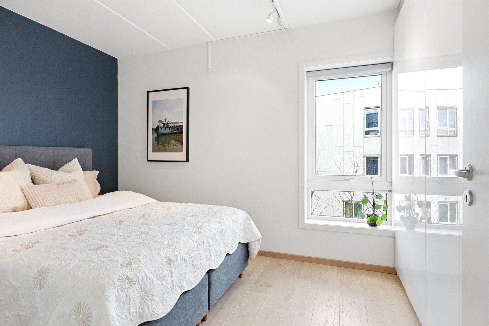 Lekkert hovedsoverom med høyglans fronter på skaprekke. Galleribilde