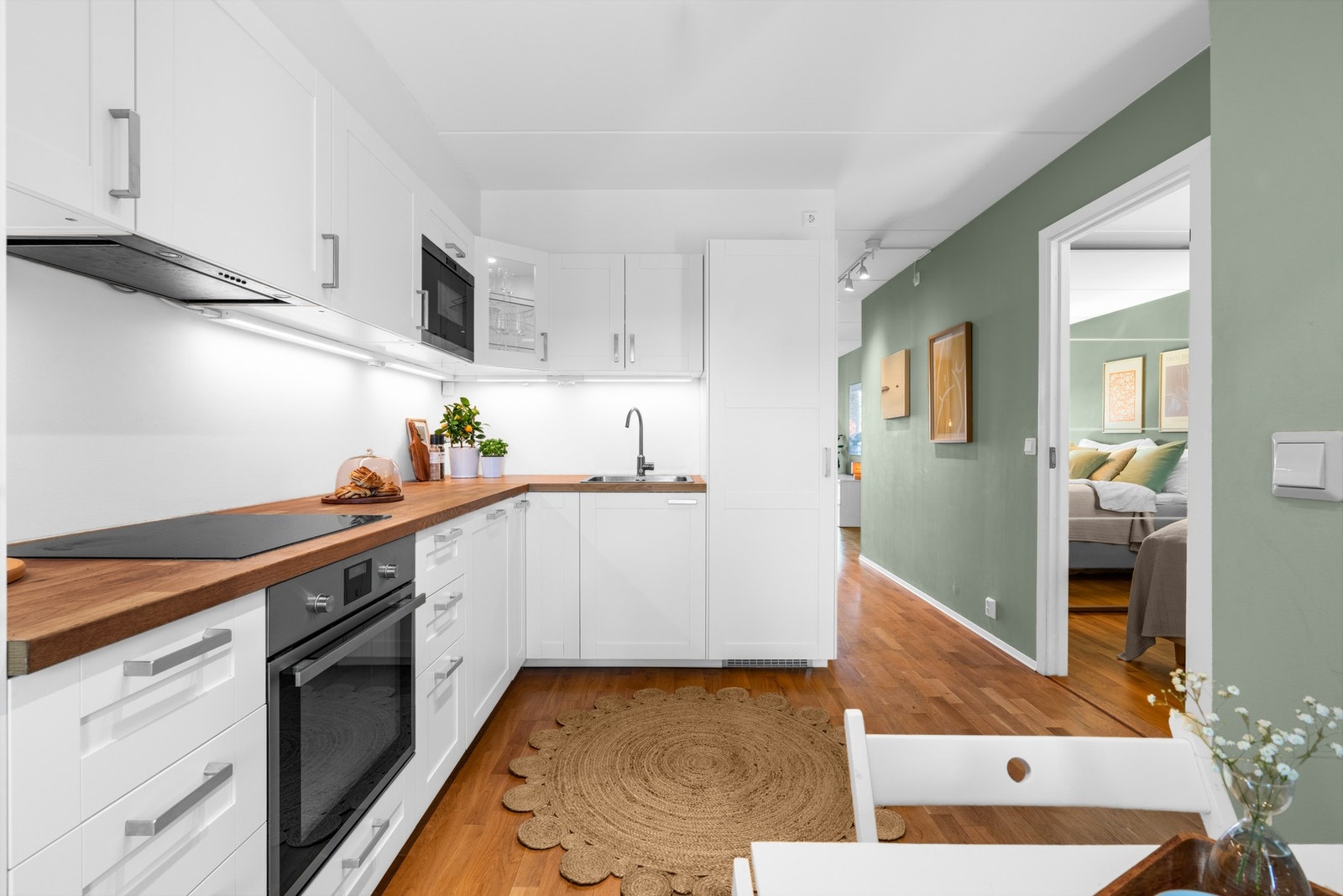 Kjøkkenet er utstyrt med en praktisk Ikea-innredning med profilerte, folierte fronter. Benkeplaten i heltre har en nedfelt kum i rustfritt stål, og det er montert ledlys under overskapene for god arbeidsbelysning. Galleribilde