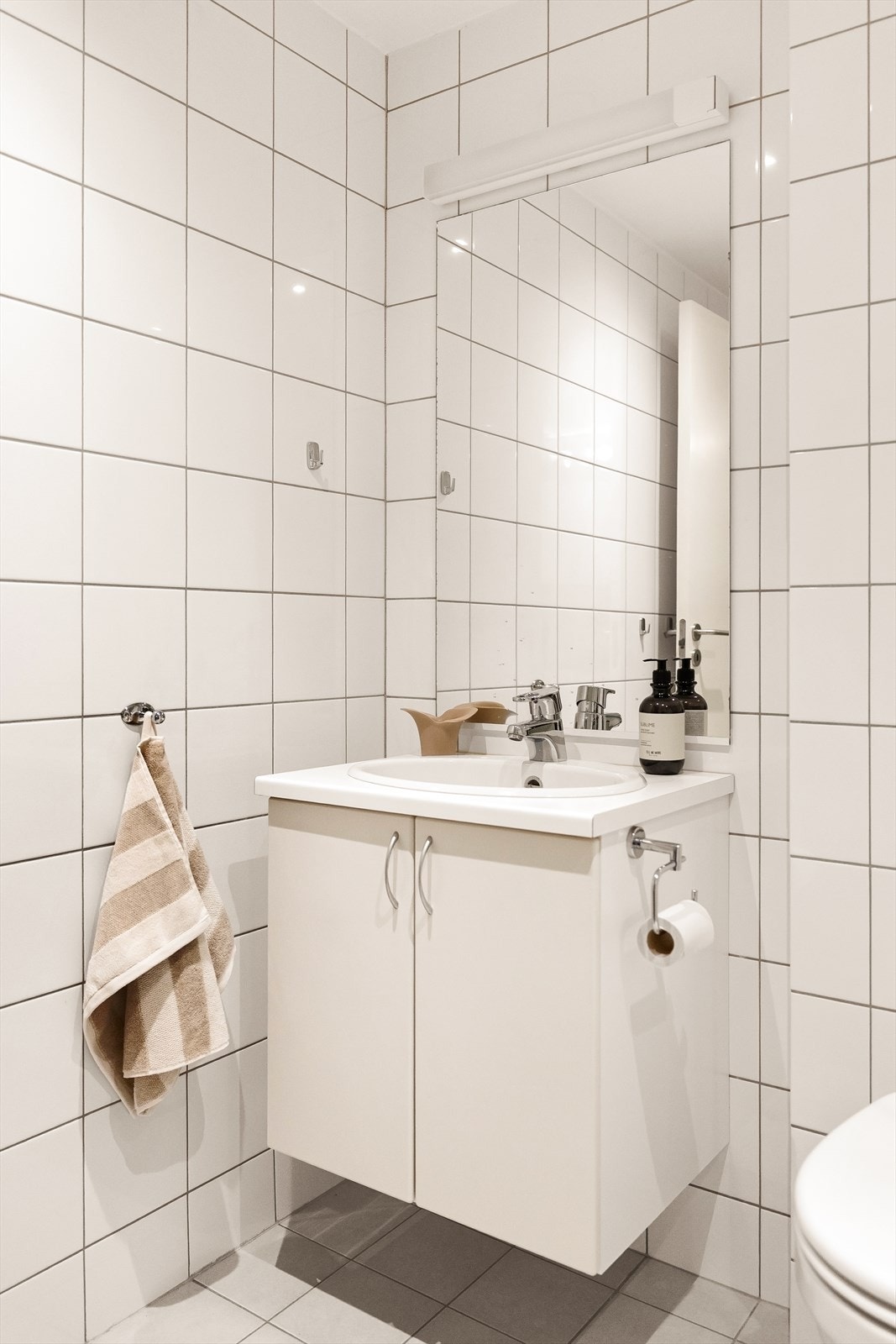 Flislagt bad med baderoms innredning, wc, dusjnisje og opplegg for vaskemaskin. Galleribilde