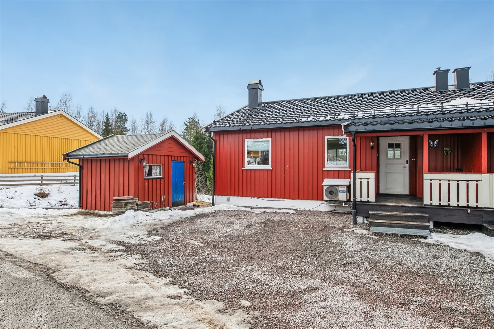 Eiendommen har en romslig, gruset biloppstillingsplass, garasje i rekke og en praktisk utebod. Galleribilde