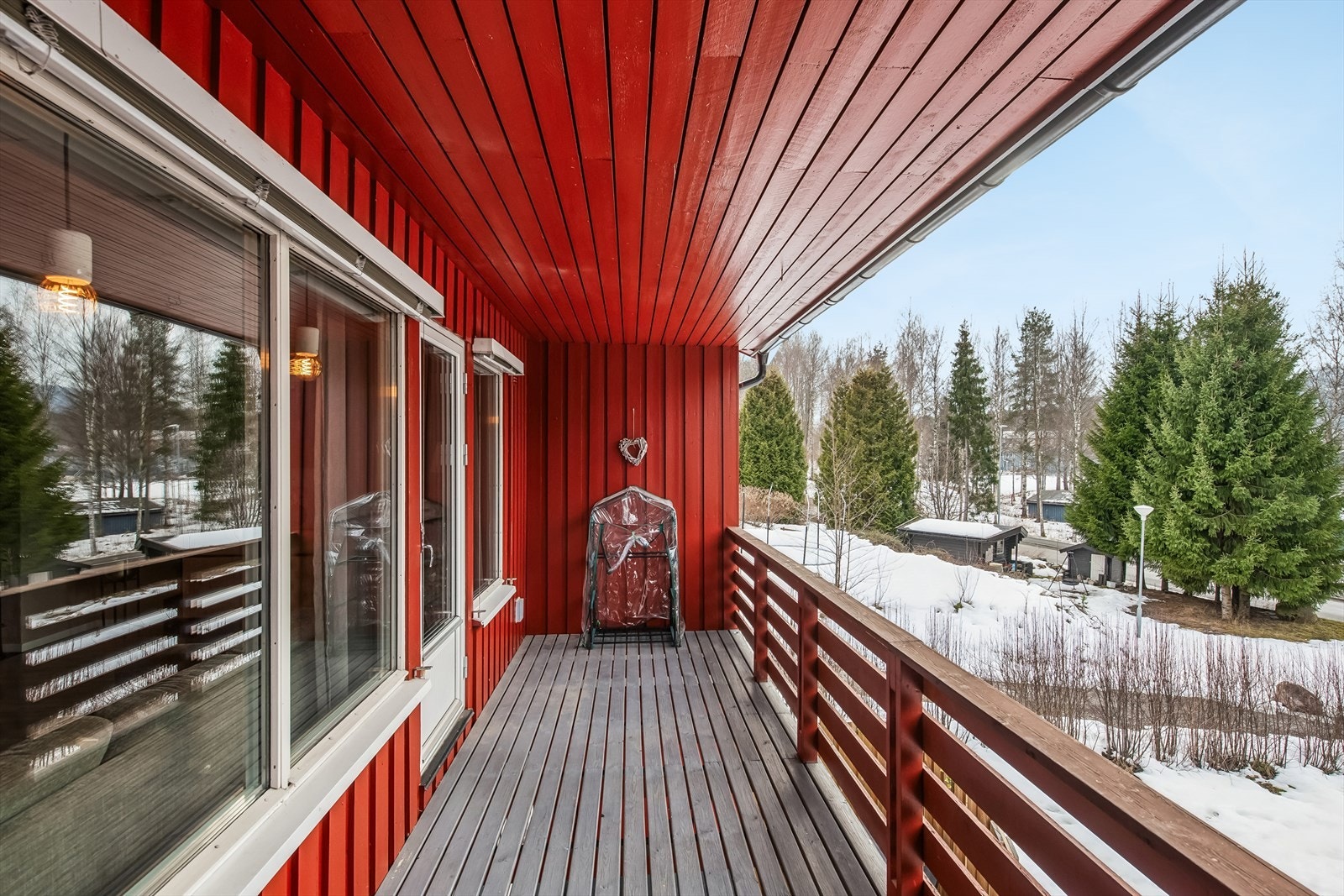 Verandaen i første etasje har rekkverk med liggende bord og levegg mot naboen, som sikrer privatliv. Galleribilde
