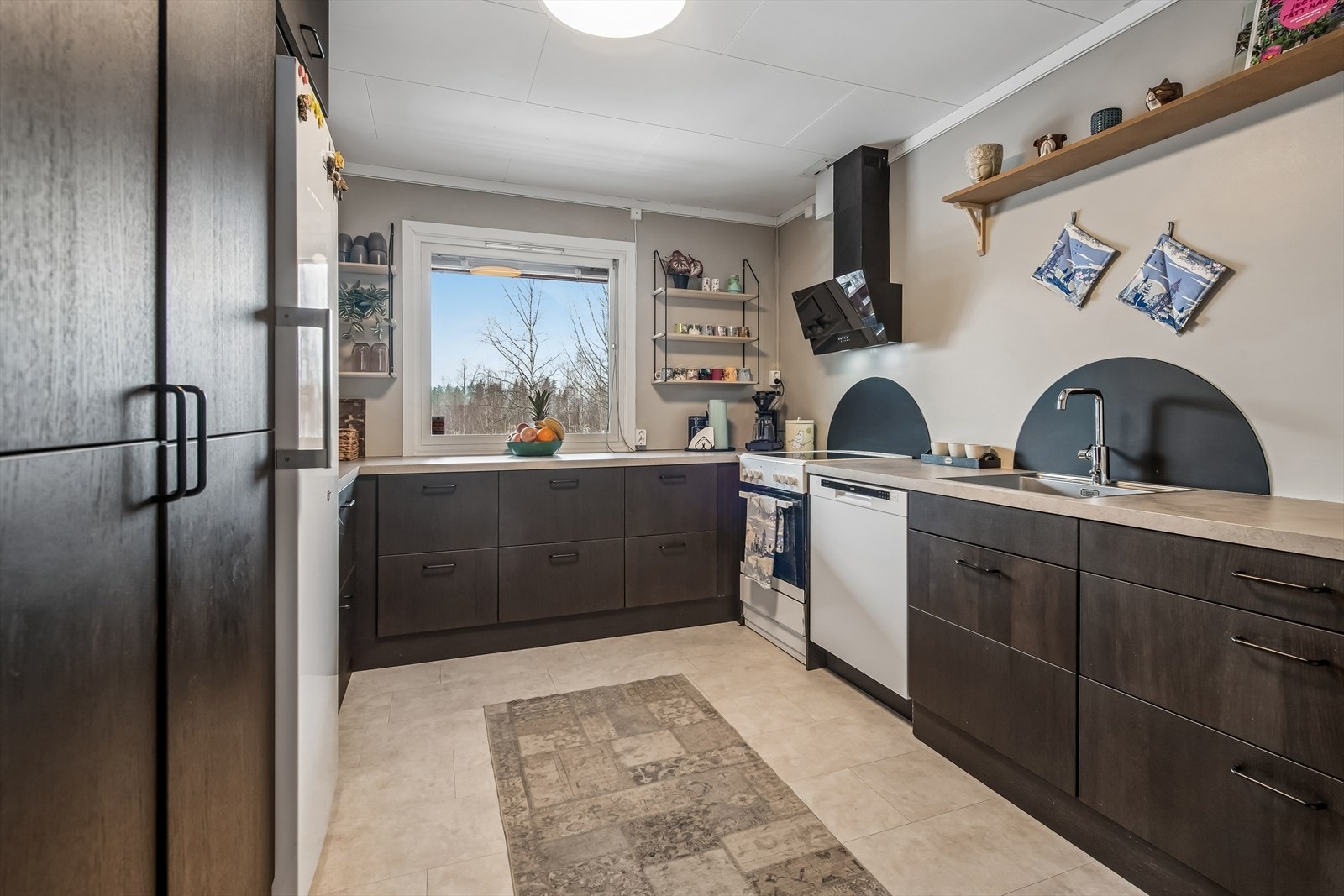 Praktisk hesteskoformet kjøkkeninnredning med slette fronter i trestruktur og laminat benkeplate. Galleribilde