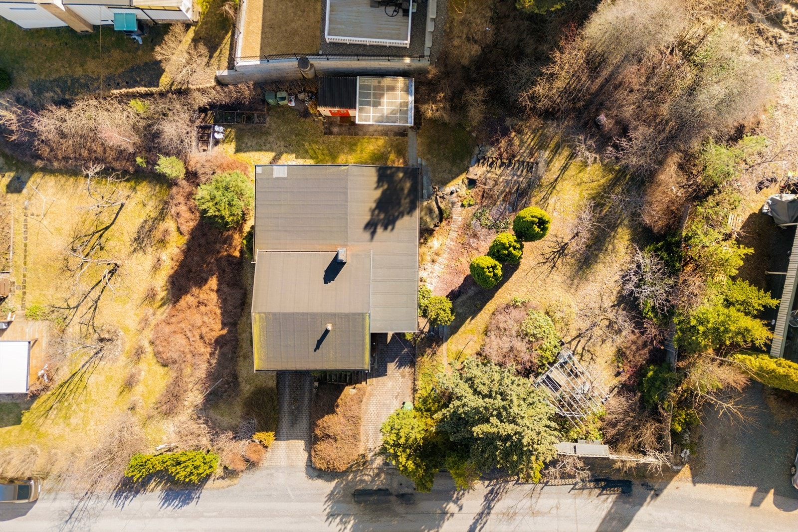 Tomten er opparbeidet med plenområde, busker og trær. Galleribilde