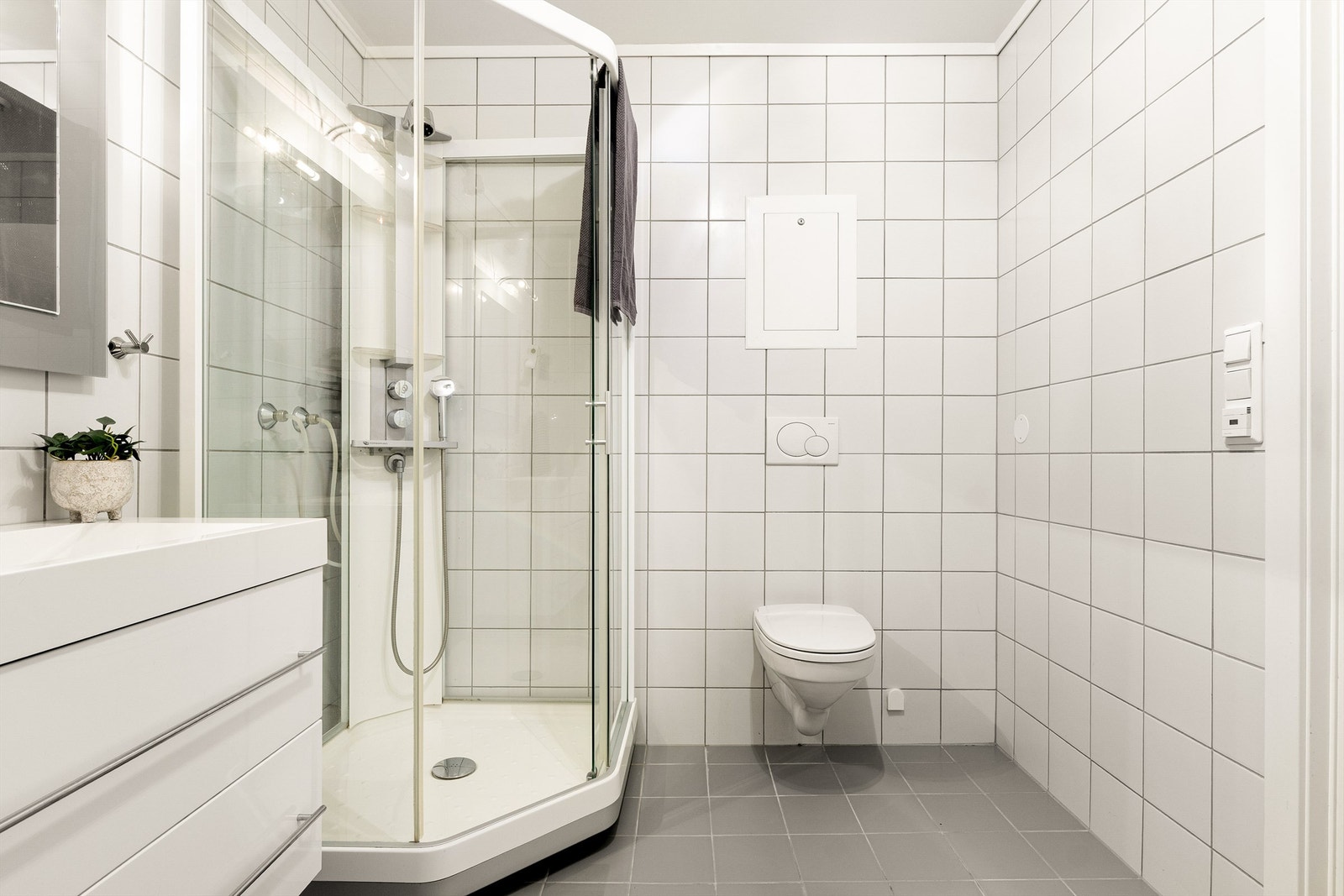Innredet med vegghengt servantinnredning, speil med lys, dusjkabinett og toalett. Det er opplegg for vaskemaskin. Galleribilde