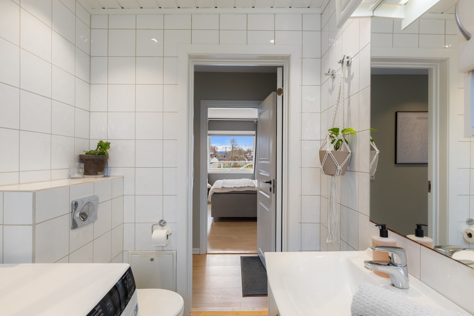 Badet er utstyrt med servantinnredning, speil med overlys og vegghengt toalett. Galleribilde