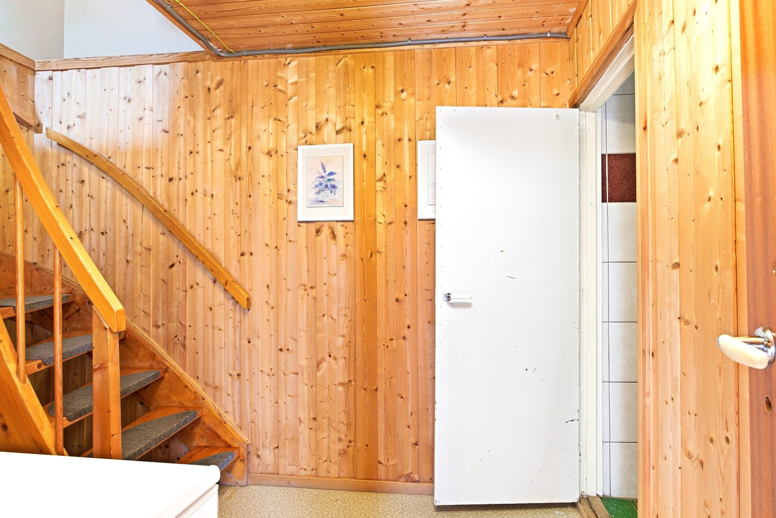 Trappeoppgang med panelvegger og lagringsplass under trappen. Galleribilde