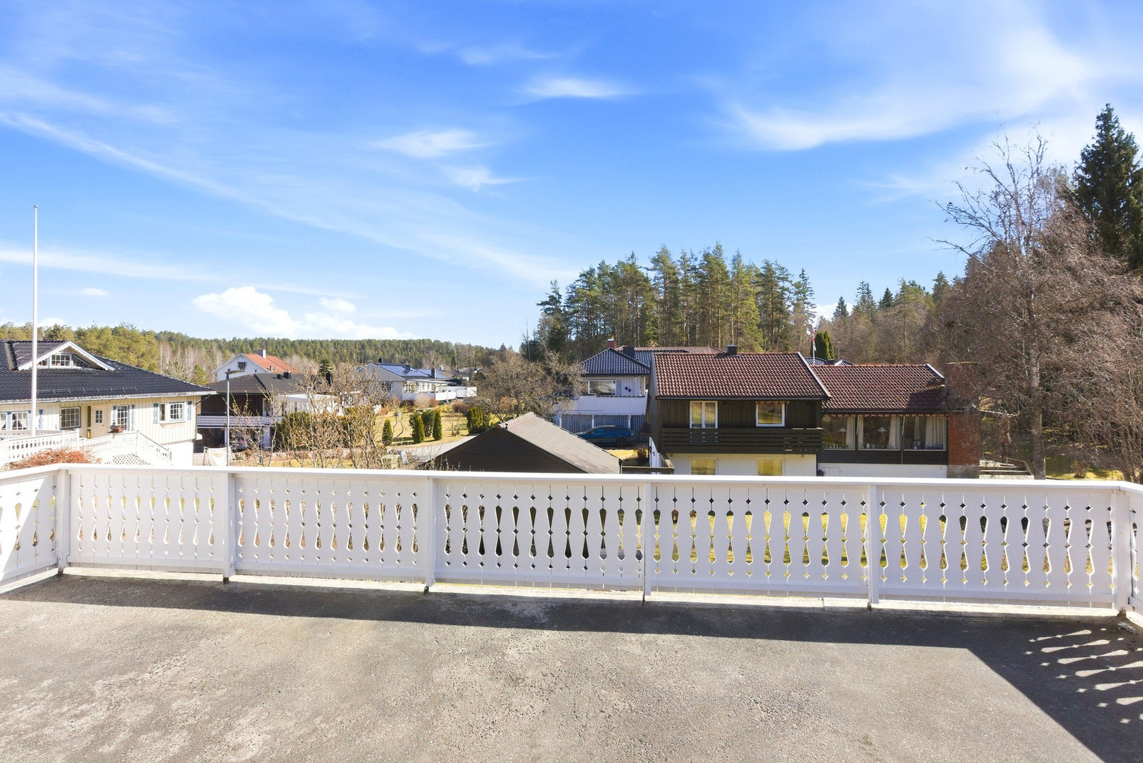 Stor terrasse med utsikt over nabolaget og omkringliggende skogsområde. Galleribilde