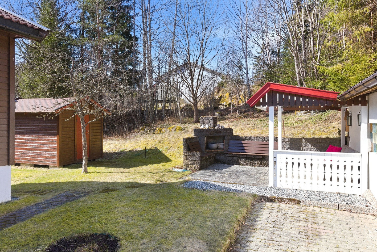 Uteområde ved garasjen har plen, steinbelagt terrasse, grillplass og redskapsbod. Galleribilde