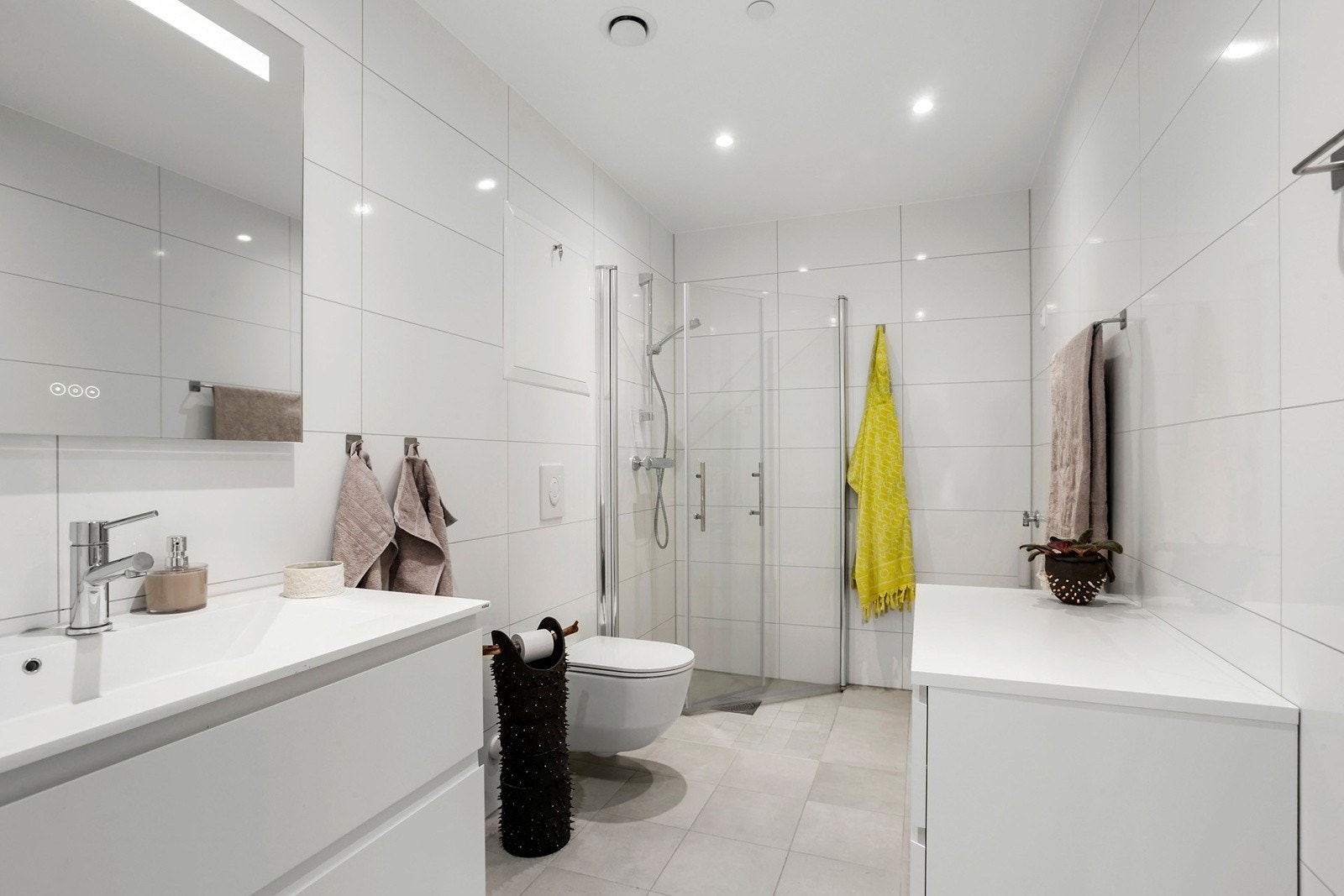 Moderne, flislagt bad/wc med elektrisk gulvvarme og downlights i himling Galleribilde