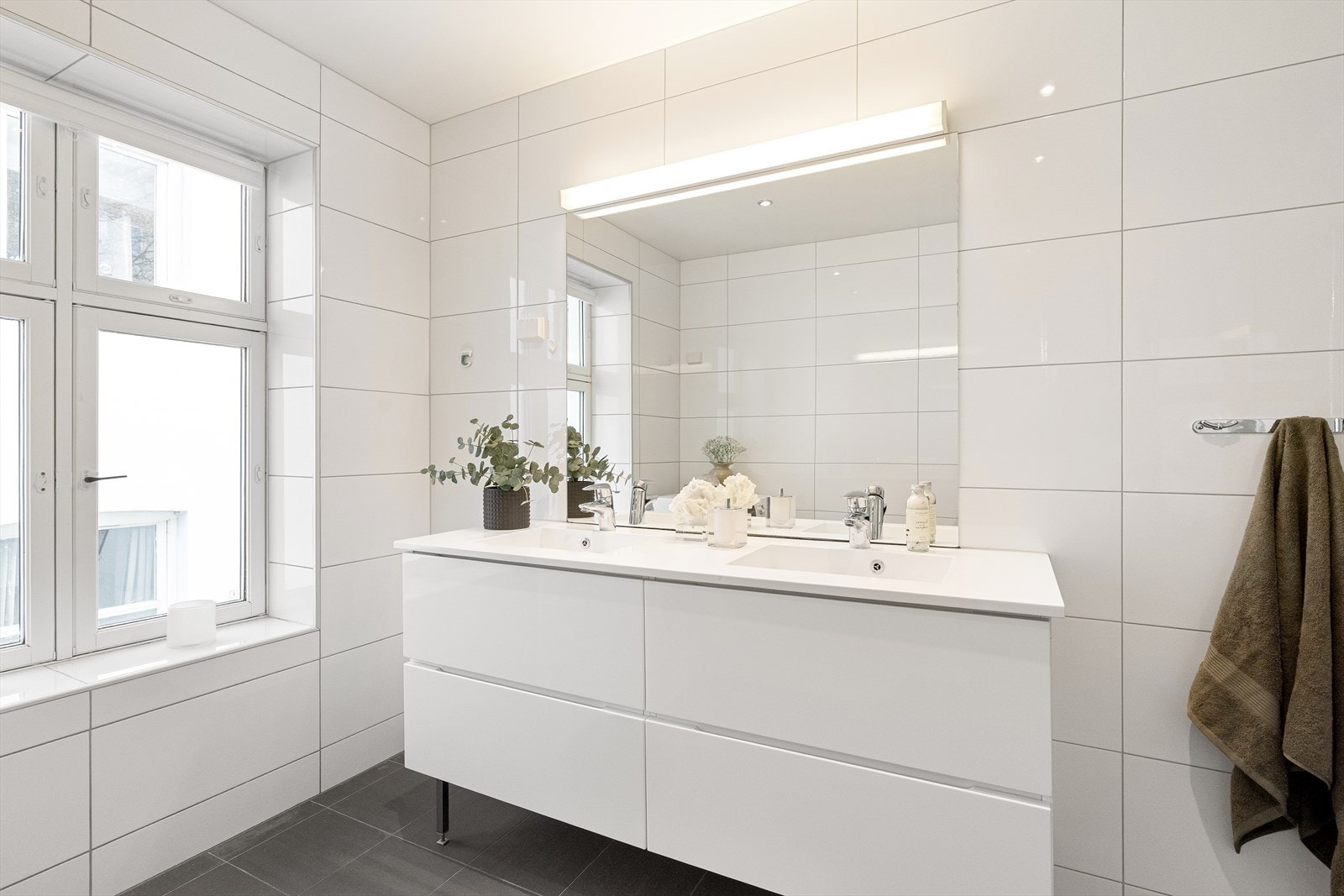 Her finner du innfellbare dusjdører, veggmontert wc og servant med ettgreps blandebatteri fra Grohe. I tillegg har badet servantskap med dobbel servant, begge med ettgreps blandebatteri fra Grohe. Galleribilde