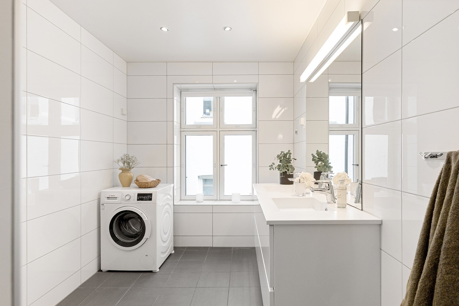 Stort og tidløst bad med gulvvarme. Badet er utstyrt med mekanisk avtrekk og opplegg for vaskemaskin. Galleribilde