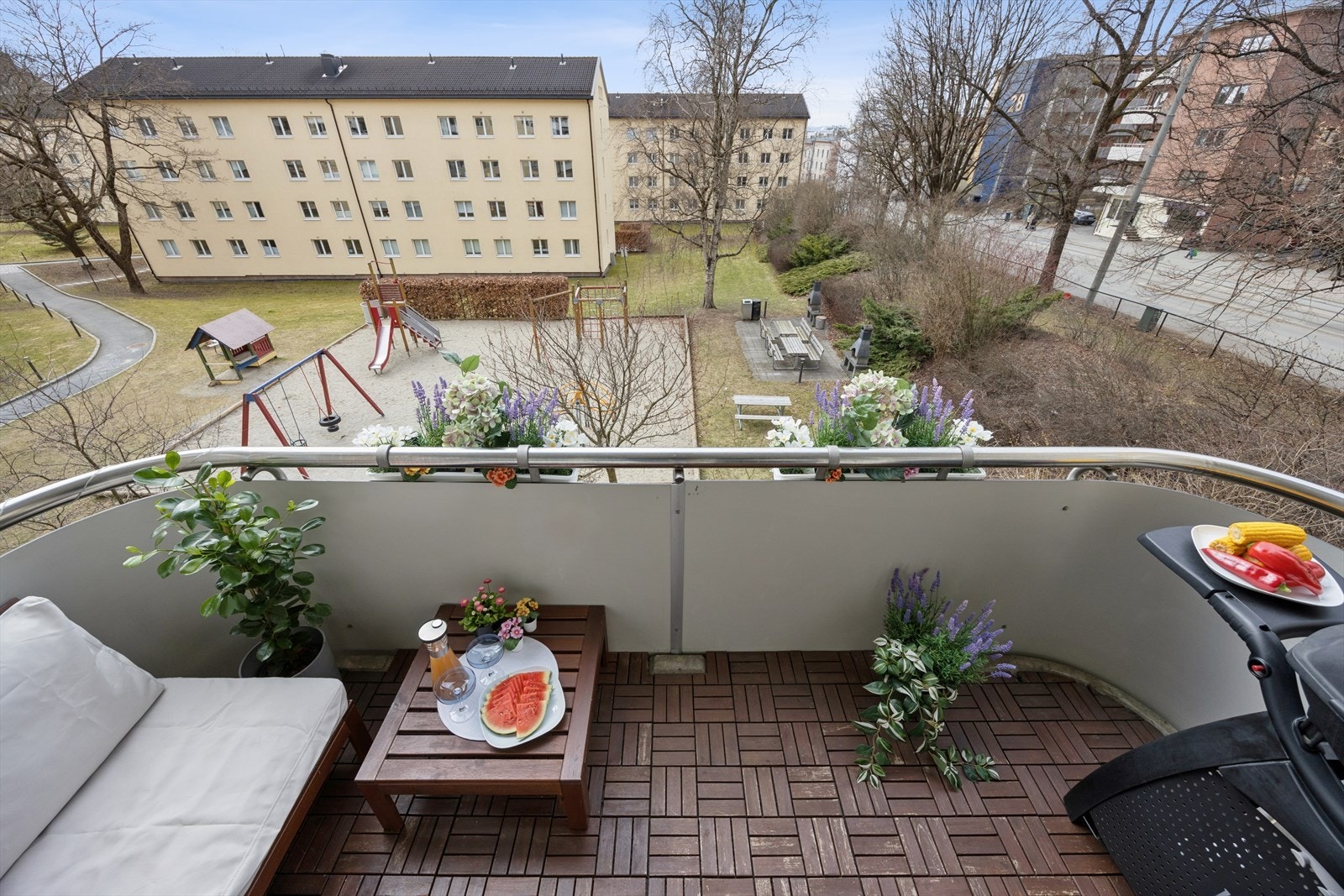Hyggelig utsyn fra balkongen mot borettslagets fellesareal. Galleribilde