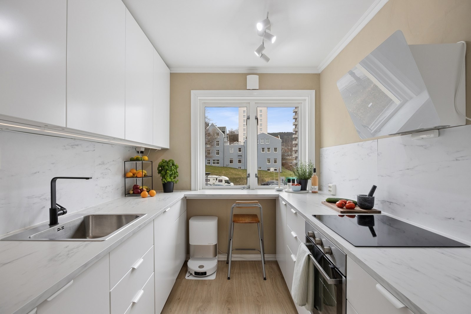 Stilrent og klassisk kjøkken med barløsning foran vindu som gir både ekstra arbeidsplass og en perfekt plass for å nyte frokosten eller ha hjemmekontor. Galleribilde