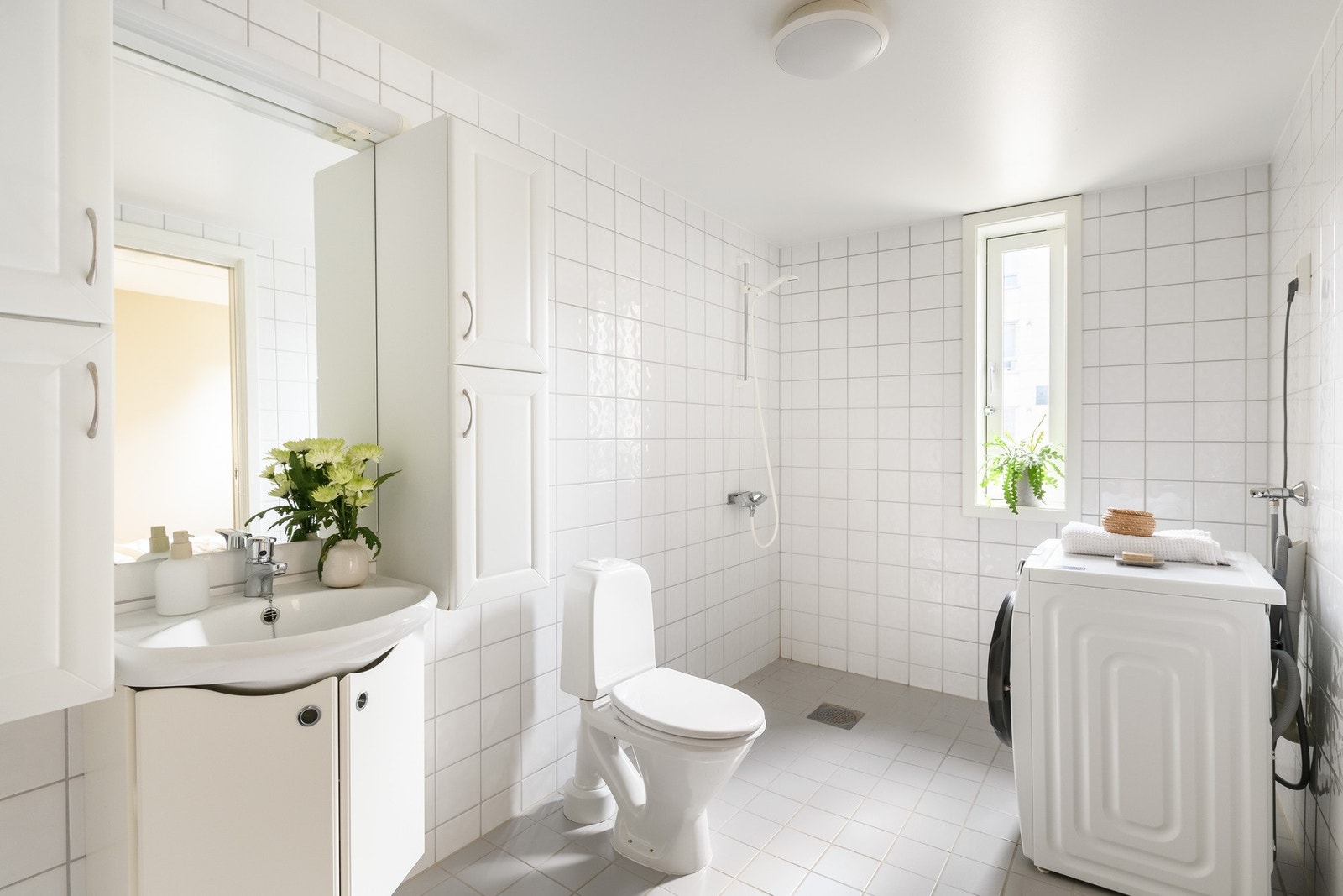 Badet er flislagt og har opplegg for vaskemaskin og plass til tørketrommel. Galleribilde