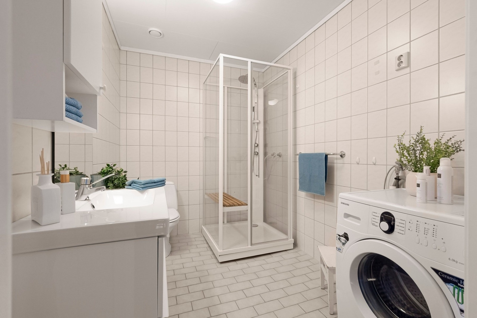 Stort baderom med varmekabler i gulvet og opplegg for vaskemaskin. Galleribilde