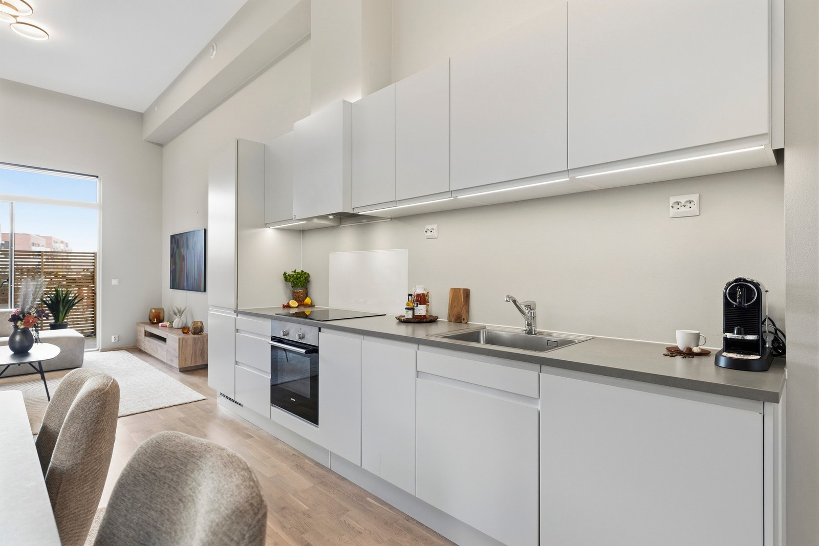 - Pent kjøkken med glatte fronter og laminat benkeplate med integrert kjøkkenkum - Galleribilde