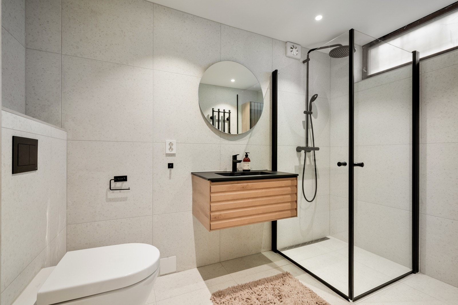 Badet i kjelleren er fra 2025 med flislagte gulv og vegger. Varmekabler og slett himling med downlights Galleribilde
