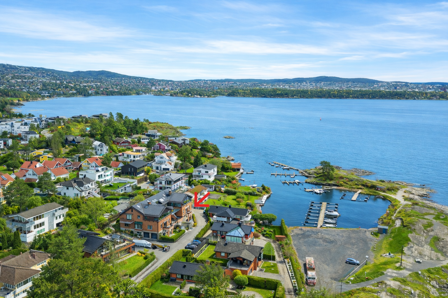 Leiligheten har en optimal beliggenhet i blindvei med god nærhet til havet, kyststier og båthavn. (AI redigert sommerbilde). Galleribilde