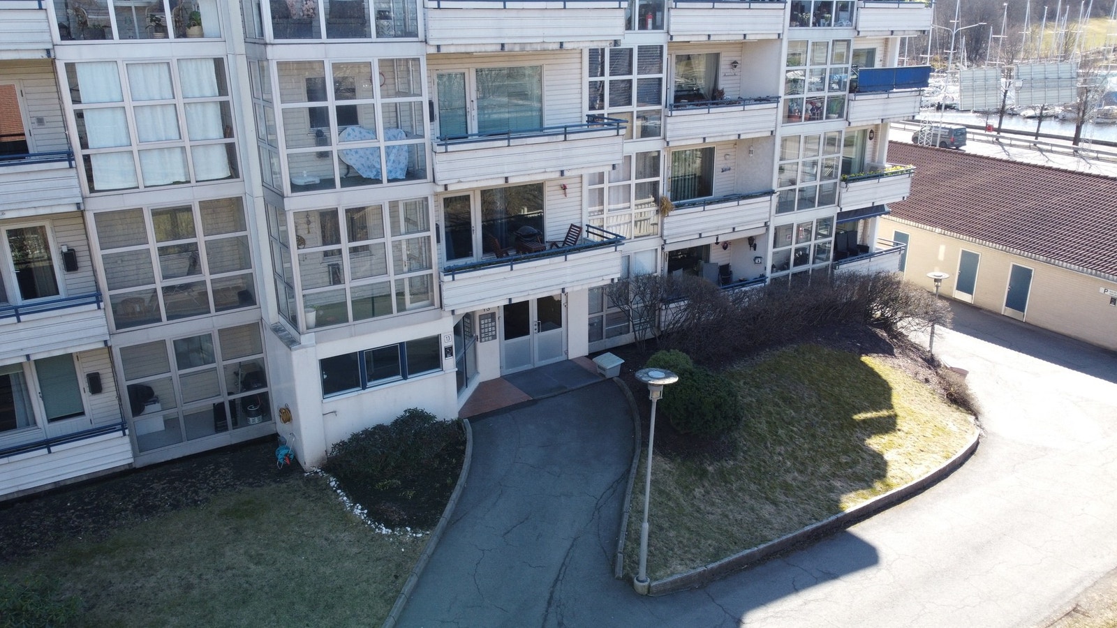Dronefoto ved inngangspartiet til leilighetsbygget. Galleribilde