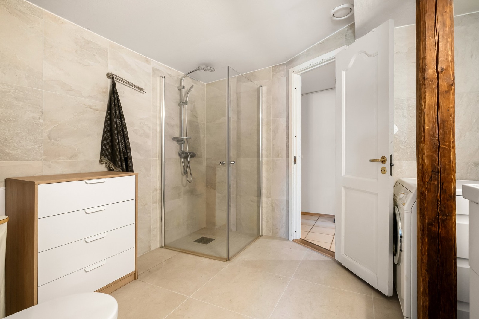 Badet har gulvvarme og er innredet med servant, toalett, dusj med svingbare glassvegger og opplegg for vaskemaskin. Galleribilde