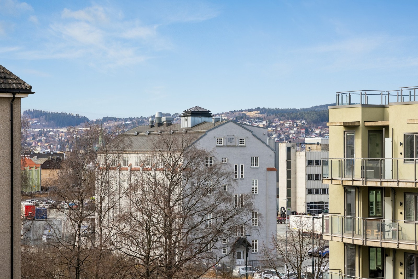 Utsikt fra balkongen. Foran leilighetsblokka er det åpent og luftig. Galleribilde