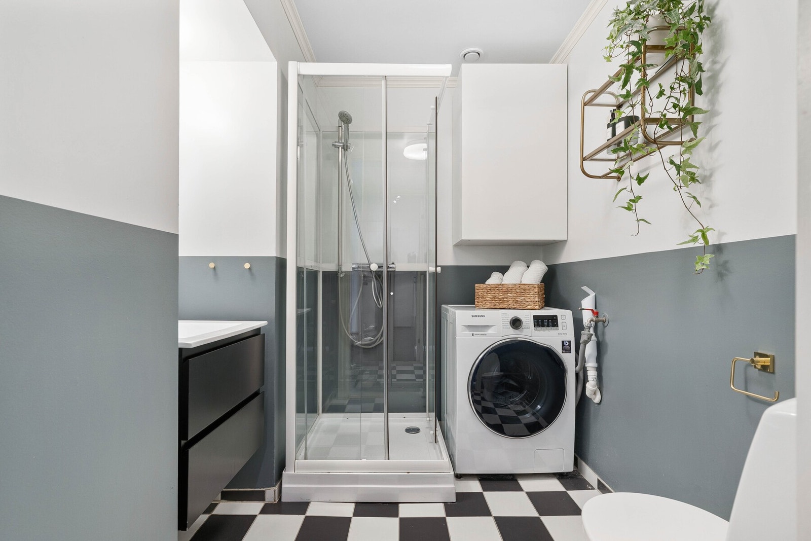 Det praktiske badet inneholder kran og avløp til vaskemaskin, gulvmontert WC og et dusjkabinett. Galleribilde