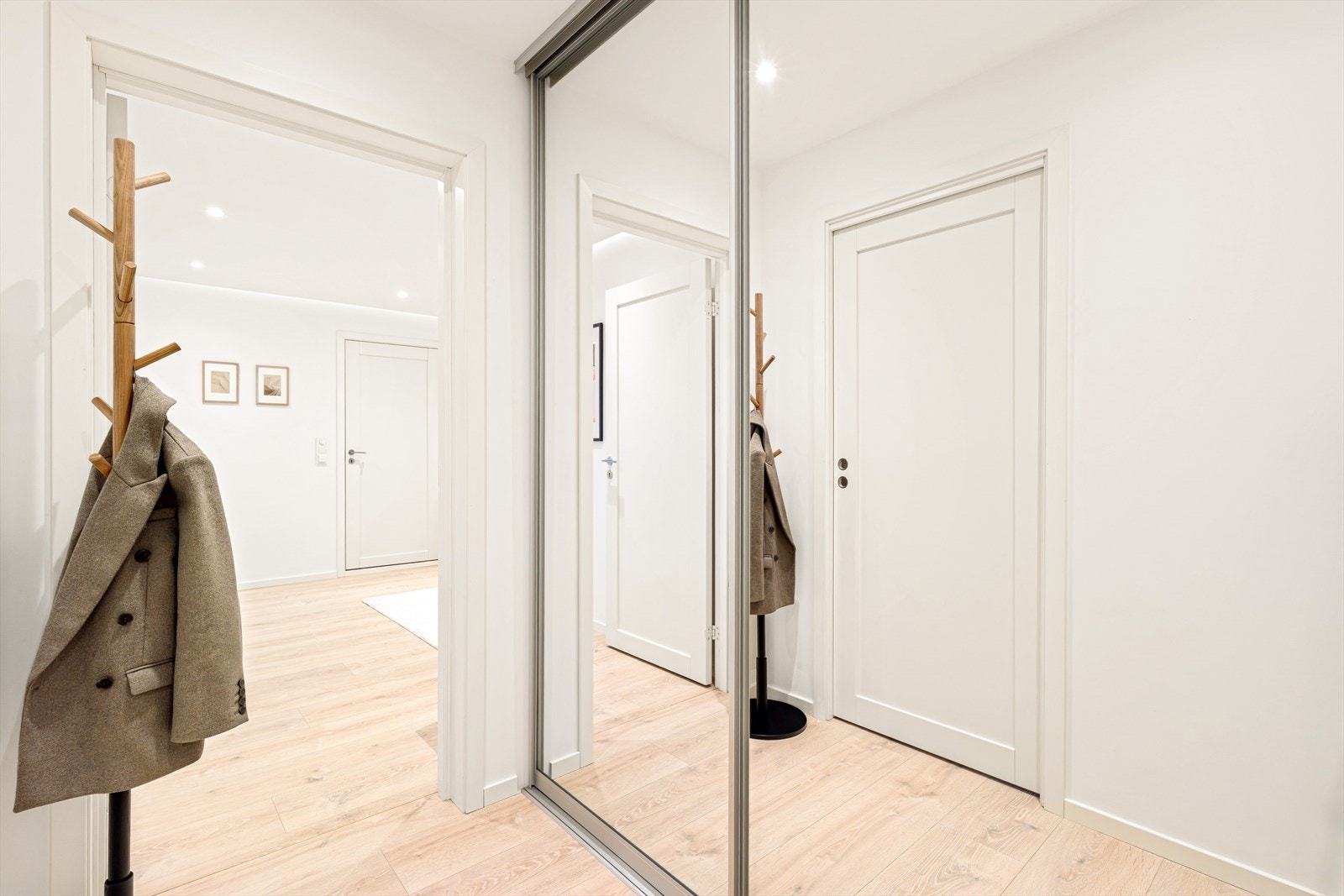 Entréen er lys og innbydende med god oppbevaringsplass i stor skyvegarderobe med speilfronter Galleribilde