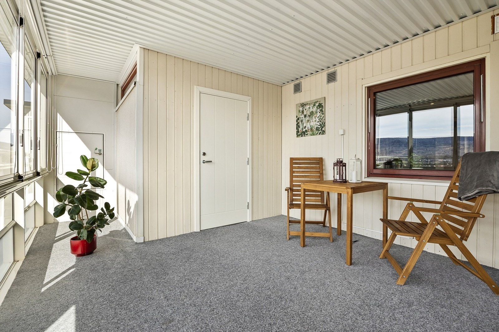 Balkongen har skyvbare glassfelt, innvendig solskjerming (lameller og rullgardin) og teppebelagt gulv. Galleribilde
