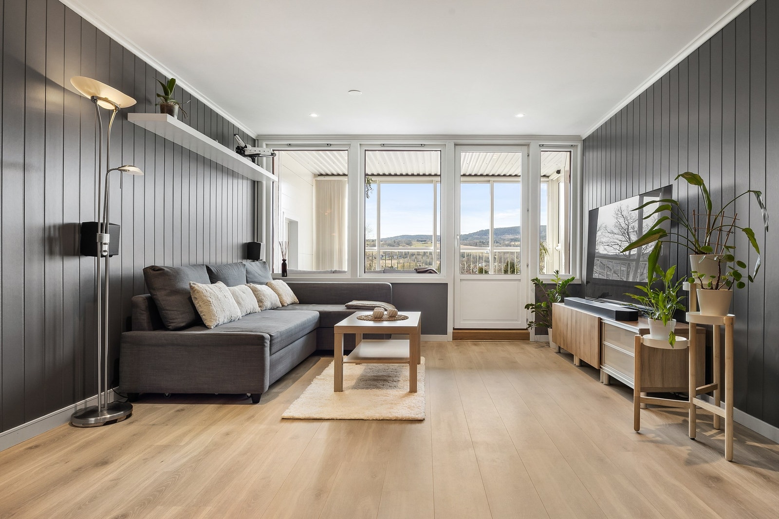 Stuen har gjennomgående laminatgulv og vegger med malte MDF-plater, som gir et helhetlig inntrykk. Galleribilde
