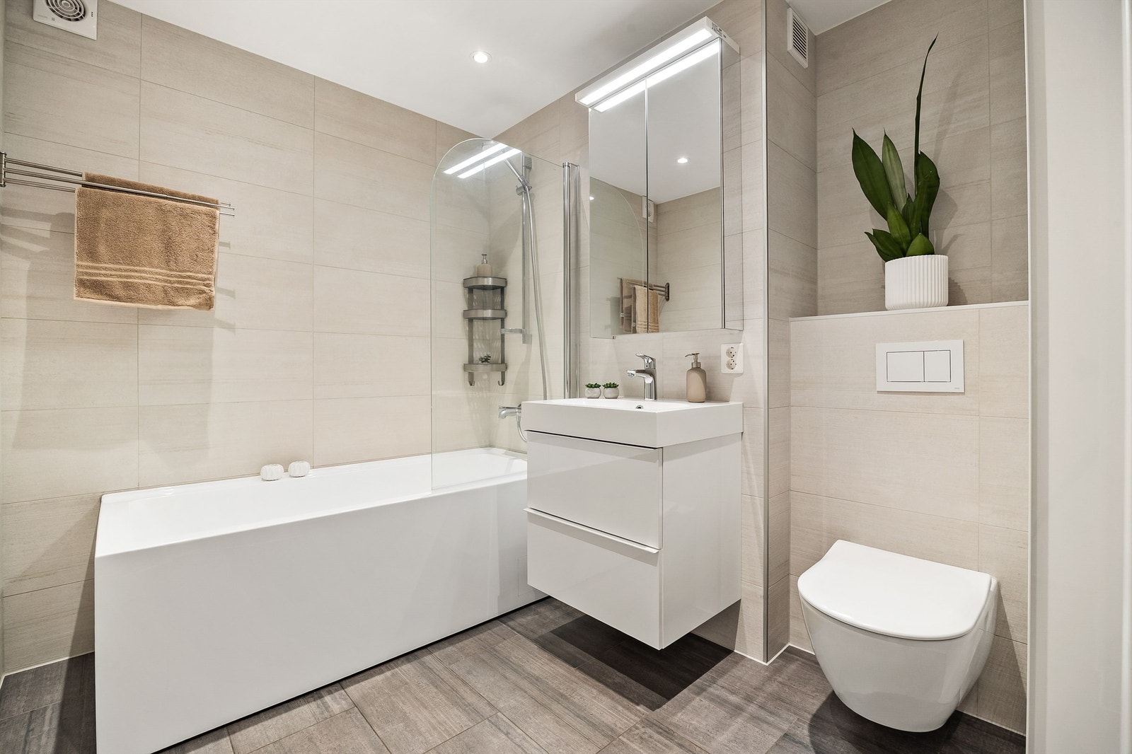 Badet er fra 2022 og har flislagt gulv med gulvvarme, badekar og vegghengt toalett. Galleribilde