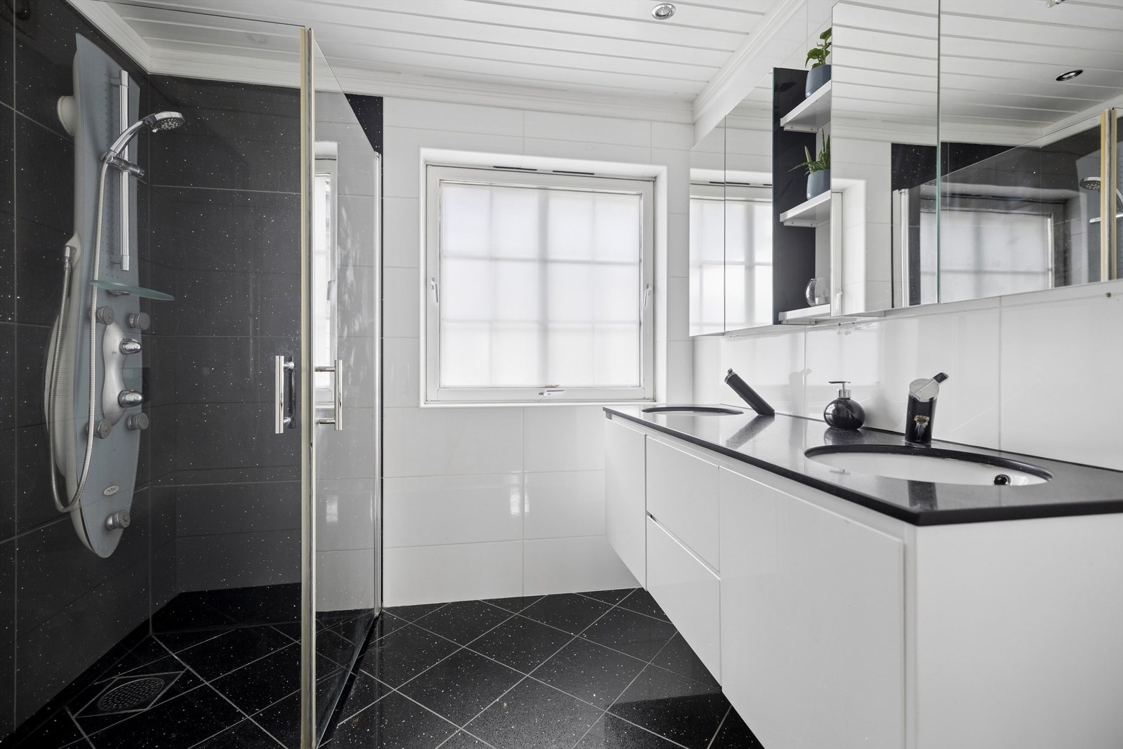 Tidløst bad med vegghengt WC og servantskap med doble servanter gir både funksjonalitet og et minimalistisk preg. Det store speilskapet gir god oppbevaringsplass. Galleribilde
