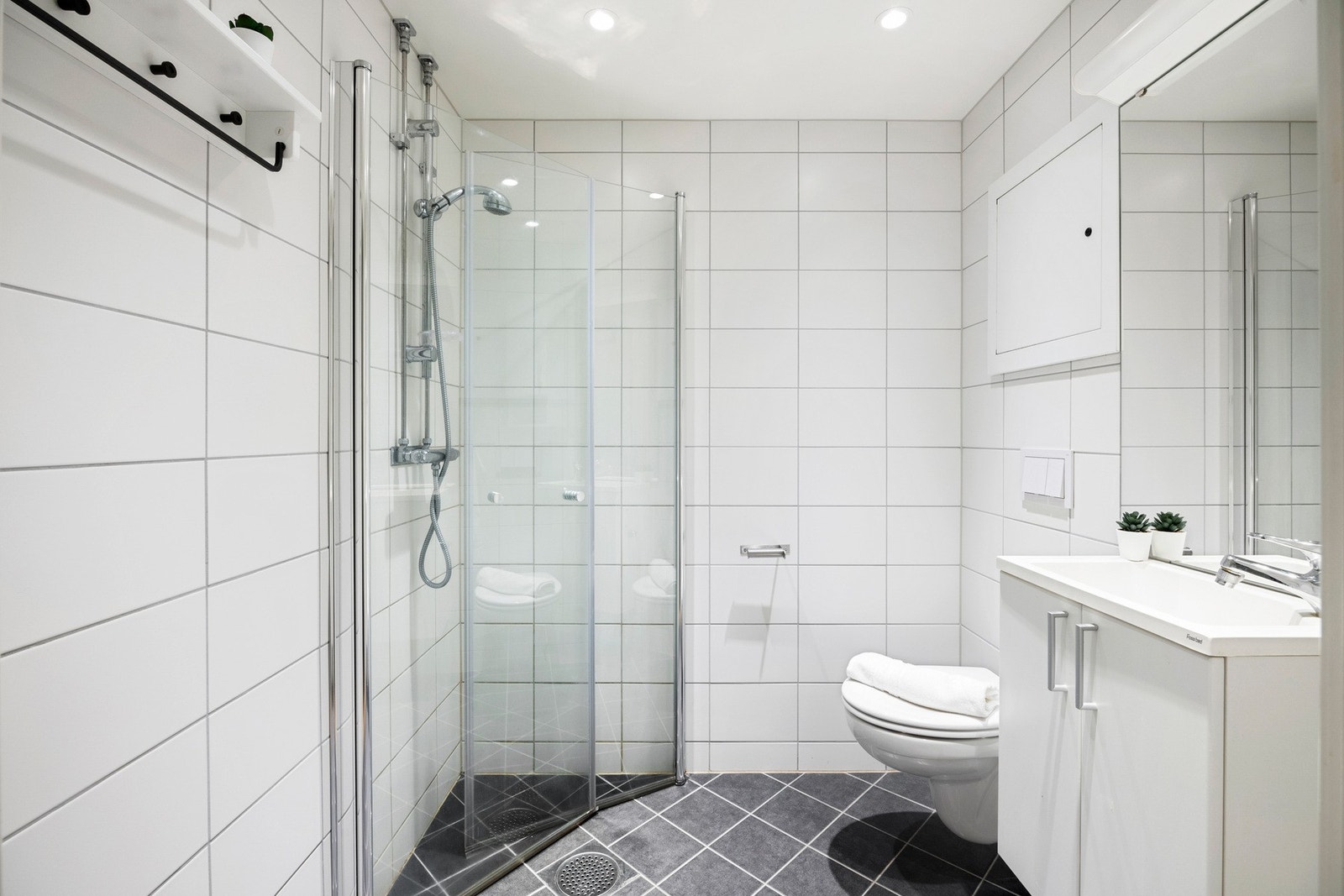 Pent, helflislagt bad fra 2017, utført i regi av borettslaget. Badet har varmekabler i gulv og er innredet med servant, vegghengt toalett og dusjnisje. Galleribilde