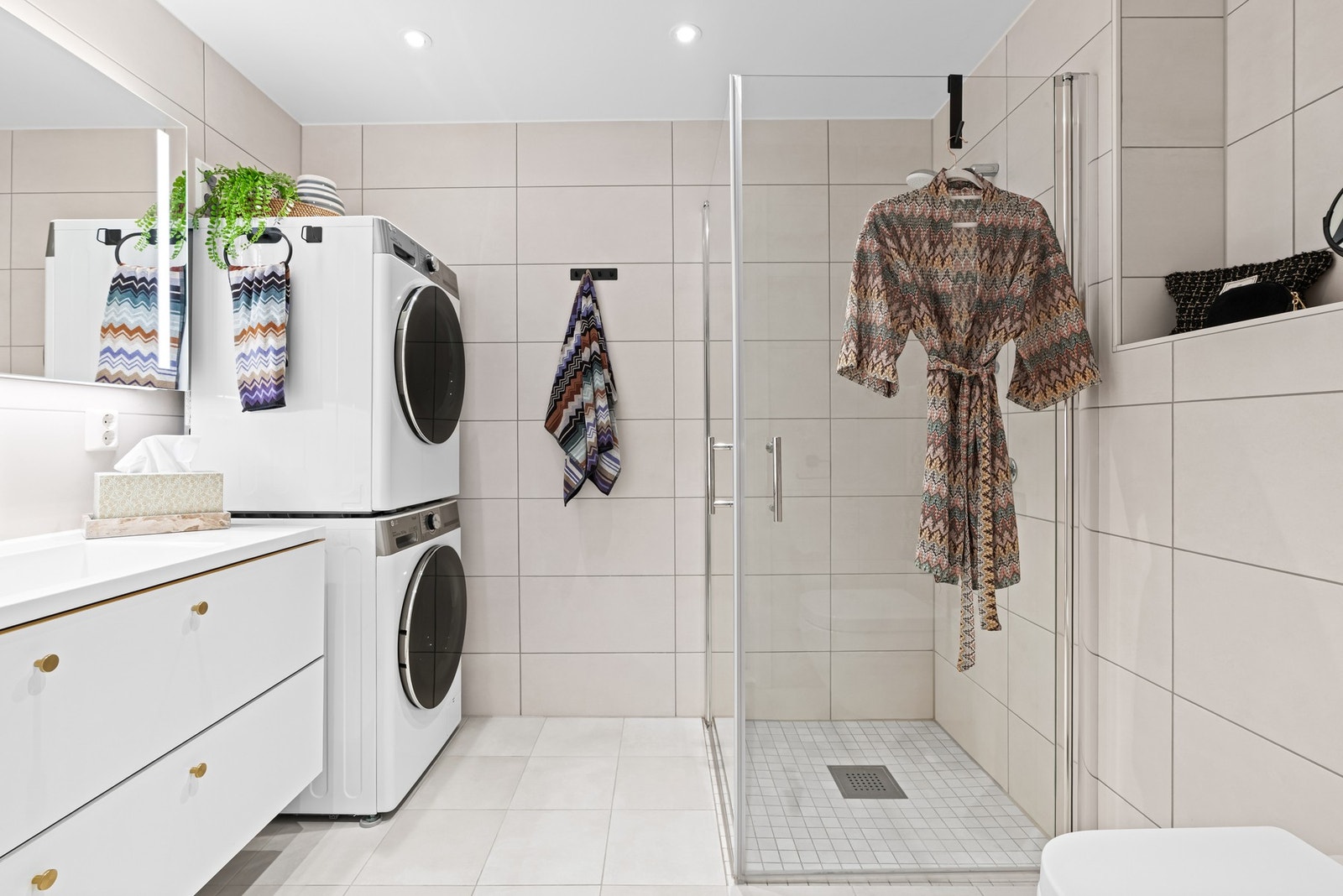 Badet har lyse, delikate fliser på vegger og gulv. Vannbåren gulvvarme for øvrig. Galleribilde