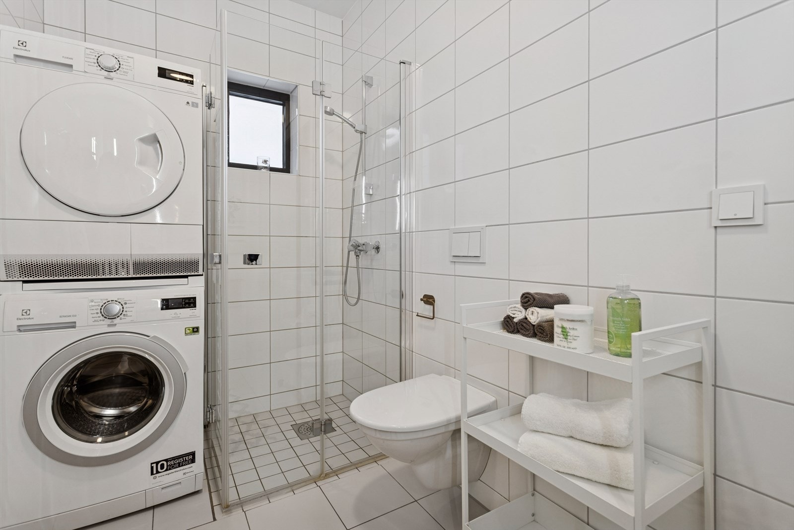 Flislagt bad på 5,1 m² utstyrt med blant annet gulvvarme, vegghengt klosett og dusjhjørne med mosaikkfliser og innfellbare dusjvegger. Galleribilde