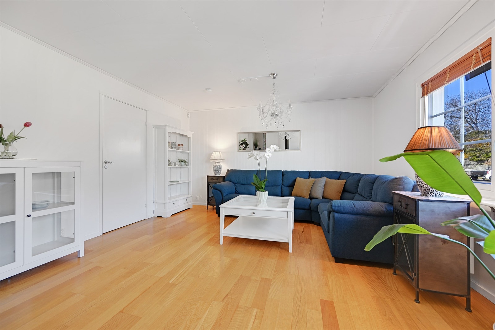Rommet har laminat på gulvet og malte plater på veggene, og god plass til en romslig sofagruppe. Galleribilde
