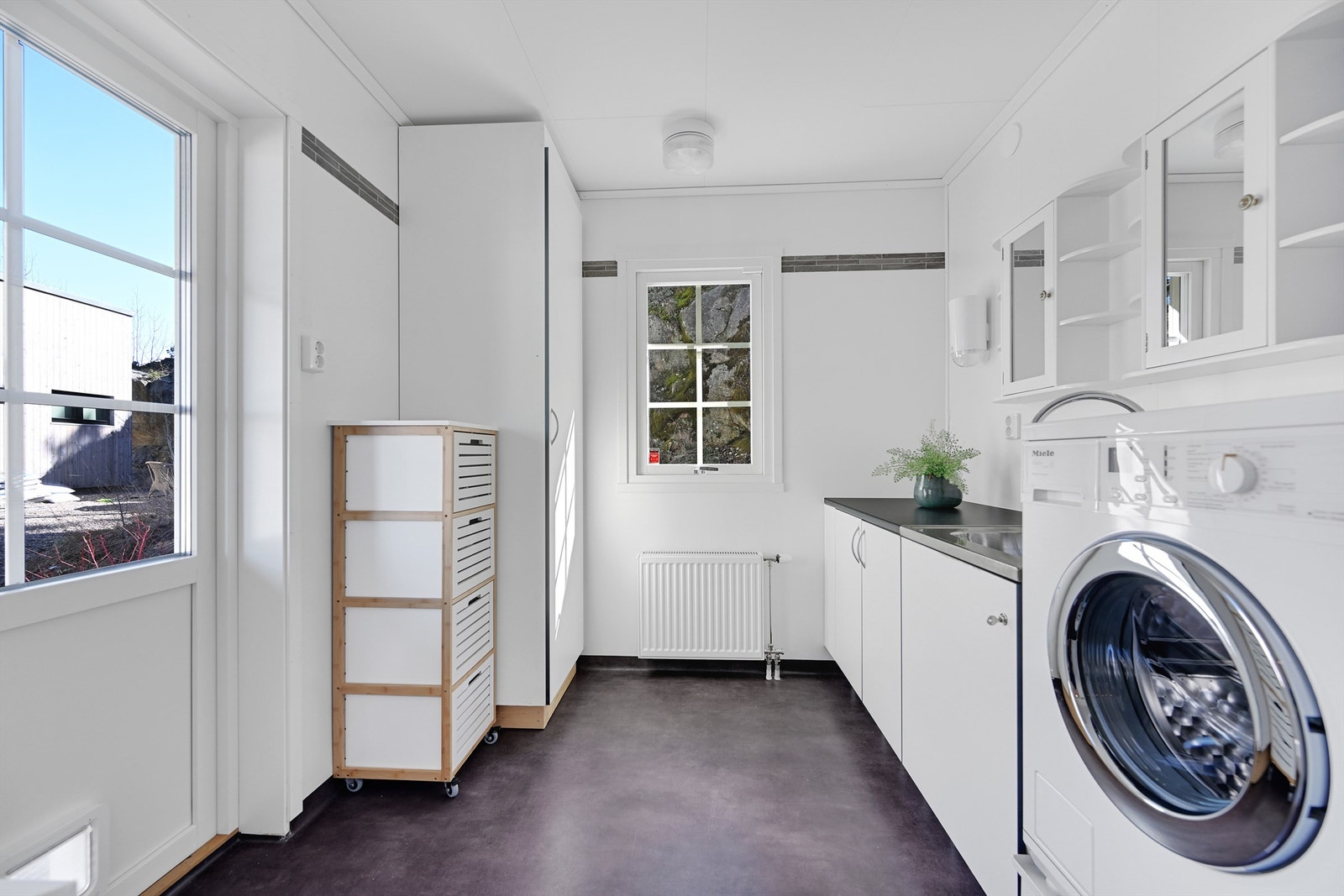 Praktisk vaskerom med egen bi-inngang, opplegg for vaskemaskin og nedfelt utslagsvask. Galleribilde
