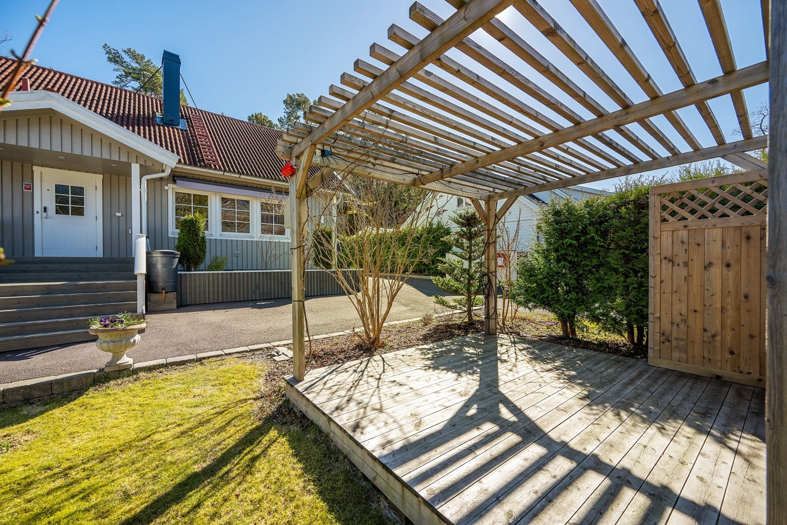 En pergola i hagen skaper en lun og definert uteplass. Galleribilde
